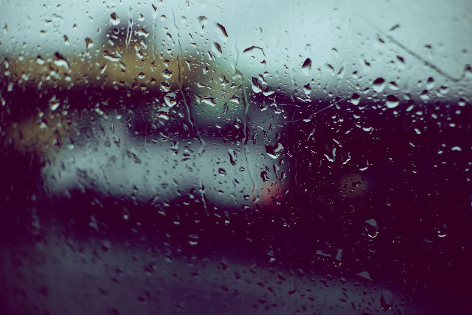 Starker Regen auf einer geschlossenen Fensterscheibe während eines Gewitters