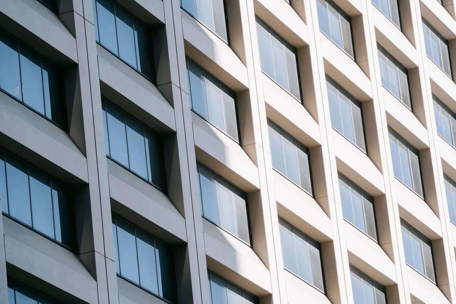 Modern facade with glazed windows divided between sunlight and shade