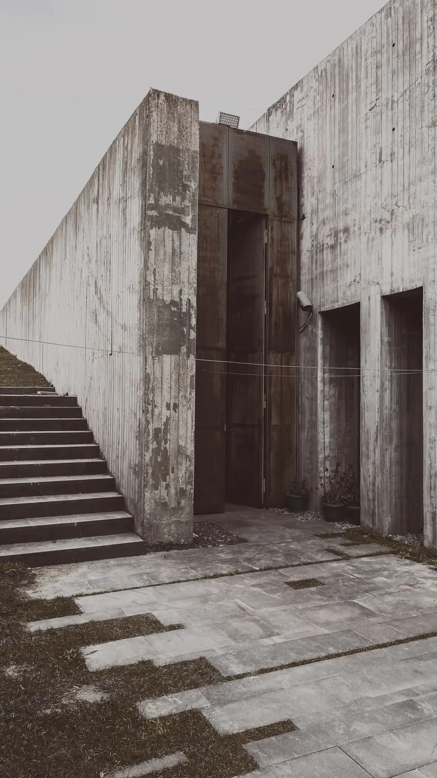 Hohe moderne Eingangstür in einer Sichtbetonfassade